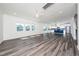 Open-concept living room and kitchen has gray wood flooring and lots of windows at 171 Piney Field Rd, Fuquay Varina, NC 27526