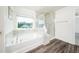 Bright bathroom features a glass enclosed shower next to a soaking tub and a large window at 171 Piney Field Rd, Fuquay Varina, NC 27526
