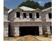 New construction shows unfinished exterior with wood framing and materials, offering a glimpse of a modern home in progress at 180 W Allen St, Four Oaks, NC 27524