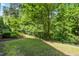 Secluded backyard featuring well-maintained landscaping, a black metal fence, and mature trees at 192 Glenpark Pl, Cary, NC 27511