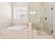 Luxurious primary bathroom featuring a soaking tub and a glass-enclosed shower with elegant tile work at 192 Glenpark Pl, Cary, NC 27511