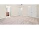 Neutral bedroom with closet and doorway view to bath featuring plush carpeting and ample natural light at 192 Glenpark Pl, Cary, NC 27511