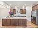 Bright kitchen boasts a large island, stainless steel appliances, custom cabinets, and gorgeous hardwood floors at 192 Glenpark Pl, Cary, NC 27511