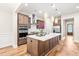 Well-appointed kitchen featuring a center island, stainless steel appliances, custom cabinets, and hardwood floors at 192 Glenpark Pl, Cary, NC 27511