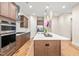 Gourmet kitchen featuring stainless appliances, center island, custom cabinetry, and hardwood floors at 192 Glenpark Pl, Cary, NC 27511
