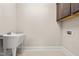 Functional laundry room with a utility sink, white tile floor, and washer-dryer hookups at 192 Glenpark Pl, Cary, NC 27511