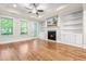 Bright living room features a fireplace, built-in shelving, hardwood floors, and access to the outside at 192 Glenpark Pl, Cary, NC 27511