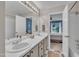 Bright bathroom featuring a double vanity and an adjoining bedroom with blue accent wall, creating a serene atmosphere at 201 Crossfire Rd, Holly Springs, NC 27540