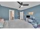 Blue bedroom featuring bed, a tv and built in shelving with natural light from the windows at 201 Crossfire Rd, Holly Springs, NC 27540