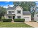 Charming two-story home with a manicured lawn, black shutters, and an attached garage at 201 Crossfire Rd, Holly Springs, NC 27540
