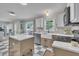 Updated kitchen with stainless steel appliances, tiled backsplash, an island, and a dining area at 201 Crossfire Rd, Holly Springs, NC 27540