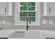 Farmhouse sink with updated fixture, view from window, and white countertops at 201 Crossfire Rd, Holly Springs, NC 27540