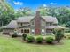 View of home's back exterior with large deck and covered porch nestled on a landscaped lawn with mature trees at 201 Village Dr, Knightdale, NC 27545