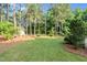 Spacious backyard with mature trees, manicured lawn and a storage shed at 201 Village Dr, Knightdale, NC 27545