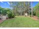 Expansive backyard with a lush lawn, mature trees, and a charming shed for storage or hobbies at 201 Village Dr, Knightdale, NC 27545