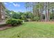 Beautiful backyard featuring a well-manicured lawn, mature trees, and lush greenery for privacy at 201 Village Dr, Knightdale, NC 27545