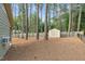 Spacious backyard featuring a storage shed, tall trees, and a wood fence at 201 Village Dr, Knightdale, NC 27545