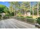 Exterior wooden deck with wooden railing and lush landscaping in the backyard at 201 Village Dr, Knightdale, NC 27545