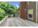 Exterior wooden deck with brick chimney and lush landscaping in the backyard at 201 Village Dr, Knightdale, NC 27545