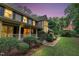 Charming home exterior featuring a covered porch, lush landscaping, and a brick walkway at 201 Village Dr, Knightdale, NC 27545