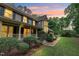Charming home exterior featuring a covered porch, lush landscaping, and a brick walkway at 201 Village Dr, Knightdale, NC 27545