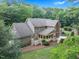 Aerial view of the back of home with a spacious wooden deck, mature trees, and green lawn at 201 Village Dr, Knightdale, NC 27545