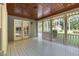 Screened porch with varnished wood ceiling and view of fenced backyard at 201 Village Dr, Knightdale, NC 27545