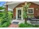 Inviting front porch with brick accents, cozy seating, and lush landscaping at 202 Hilltop Ave, Garner, NC 27529