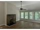 Bright living room with stone fireplace, ceiling fan, and large windows overlooking the yard at 2032 Sherry Lynn Dr, Garner, NC 27529