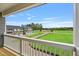 Balcony view of new homes, large green space, and a paved road on a sunny day with blue sky at 209 Broomgrove Way, Wake Forest, NC 27587