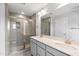Modern bathroom features a glass shower, double sink vanity with light grey cabinets, and a large mirror at 209 Broomgrove Way, Wake Forest, NC 27587
