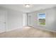 Bright, empty bedroom with neutral carpet, light grey walls, and windows allowing natural light at 209 Broomgrove Way, Wake Forest, NC 27587