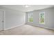 A bright bedroom with neutral carpet, two windows, and a closet creates a cozy and inviting space at 209 Broomgrove Way, Wake Forest, NC 27587