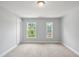 A bright bedroom with neutral carpet and two windows is a blank canvas for creating a tranquil retreat at 209 Broomgrove Way, Wake Forest, NC 27587
