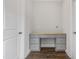 Built-in desk area with storage drawers, light grey cabinets, hardwood floors, and light grey walls is adjacent to a door at 209 Broomgrove Way, Wake Forest, NC 27587