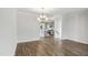 Open-concept dining area with hardwood floors and gray walls, adjacent to a modern kitchen at 209 Broomgrove Way, Wake Forest, NC 27587