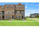 New townhome construction showcasing brick facade, multiple stories, and manicured lawn at 209 Broomgrove Way, Wake Forest, NC 27587
