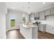 Modern kitchen features stainless appliances, grey cabinets, granite counters, and an island with sink and pendant lights at 209 Broomgrove Way, Wake Forest, NC 27587
