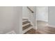 Wooden staircase leading to the upper level, complemented by a white wall and hardwood floors at 209 Broomgrove Way, Wake Forest, NC 27587