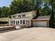 Spacious backyard featuring stone patio with a built-in seating area and manicured landscaping at 223 Shadowbrook Dr, Burlington, NC 27215