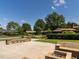 Backyard patio featuring stone seating, beautiful landscaping, and additional outdoor structures at 223 Shadowbrook Dr, Burlington, NC 27215
