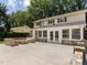 Backyard patio featuring a custom stone seating area, lush landscaping, and access to the home at 223 Shadowbrook Dr, Burlington, NC 27215