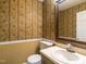 Bathroom with decorative wallpaper, single sink vanity, mirror, and toilet, offering a tranquil private space at 223 Shadowbrook Dr, Burlington, NC 27215