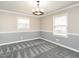 Cozy bedroom with a decorative light fixture, chair rail, and neutral carpet at 223 Shadowbrook Dr, Burlington, NC 27215