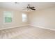 Spacious bedroom featuring neutral walls, plush carpet, and natural light from two windows at 223 Shadowbrook Dr, Burlington, NC 27215