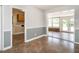 Dining area with tile floors leading to the kitchen and sunroom with ample light at 223 Shadowbrook Dr, Burlington, NC 27215