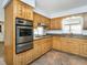 Well-equipped kitchen with stainless steel appliances, wooden cabinets, and tile floors at 223 Shadowbrook Dr, Burlington, NC 27215