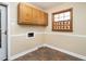 Functional laundry room with wood cabinets, tile floors, window, and connection hookups, offering convenience and style at 223 Shadowbrook Dr, Burlington, NC 27215