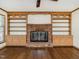 Living room with brick fireplace, custom built-ins, and hardwood floors at 223 Shadowbrook Dr, Burlington, NC 27215