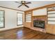 Cozy living room featuring hardwood floors, a fireplace, and built-in shelving at 223 Shadowbrook Dr, Burlington, NC 27215